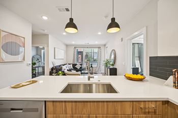 Modern kitchen island with white countertops and pendant lighting